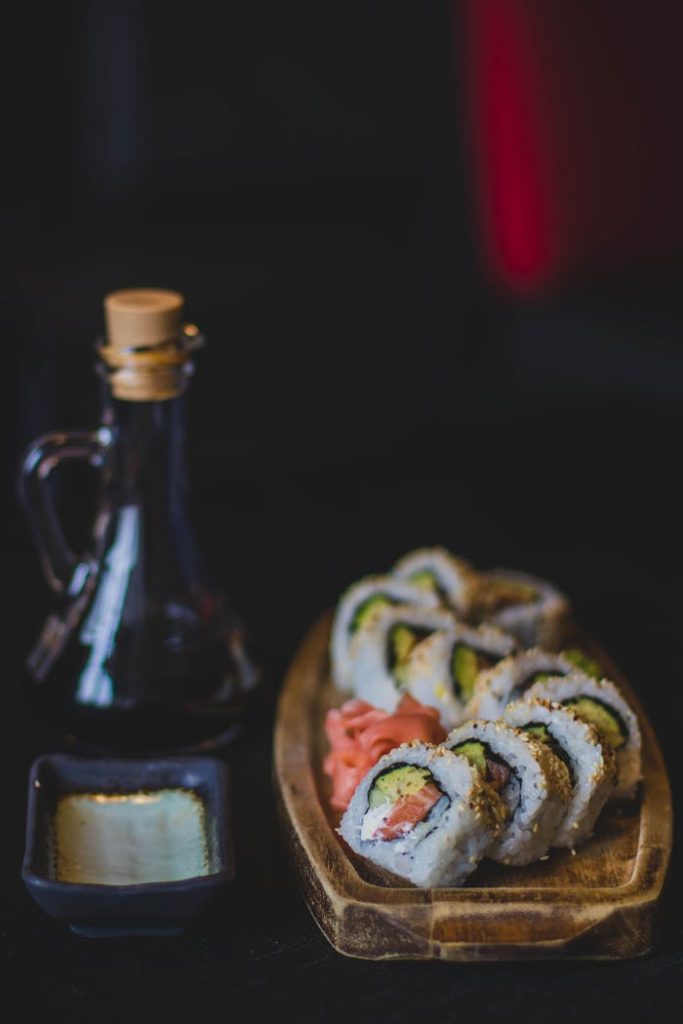 Artistic sushi rolls with soy sauce and wasabi in a restaurant setting.